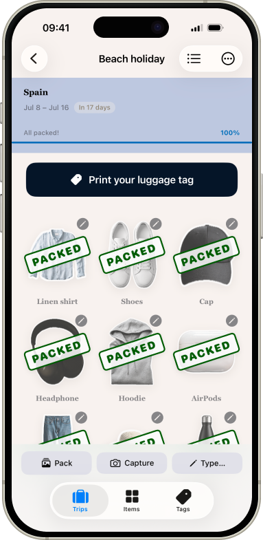 The SnapPack app showing a beach holiday trip to Spain, fully packed, with photo stickers of a shirt, shoes, cap and headphones marked as packed.